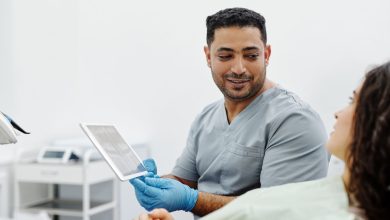 Profissional de saúde usa um tablet durante consulta e atendimento clínico.