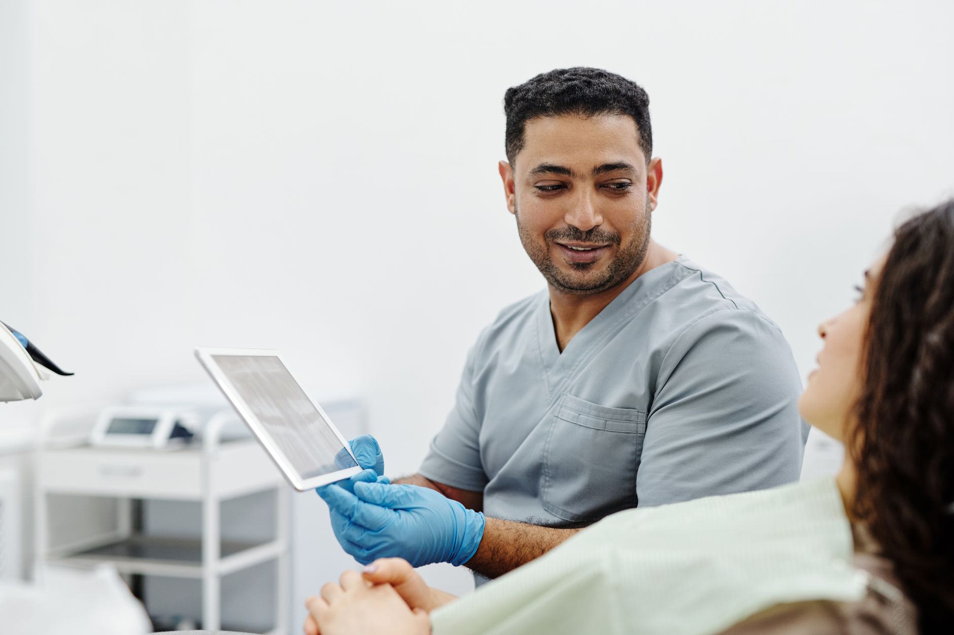 Profissional de saúde usa um tablet durante consulta e atendimento clínico.