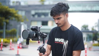 Jovem cineasta grava uma produção ao ar livre usando uma câmera acoplada a um gimbal.