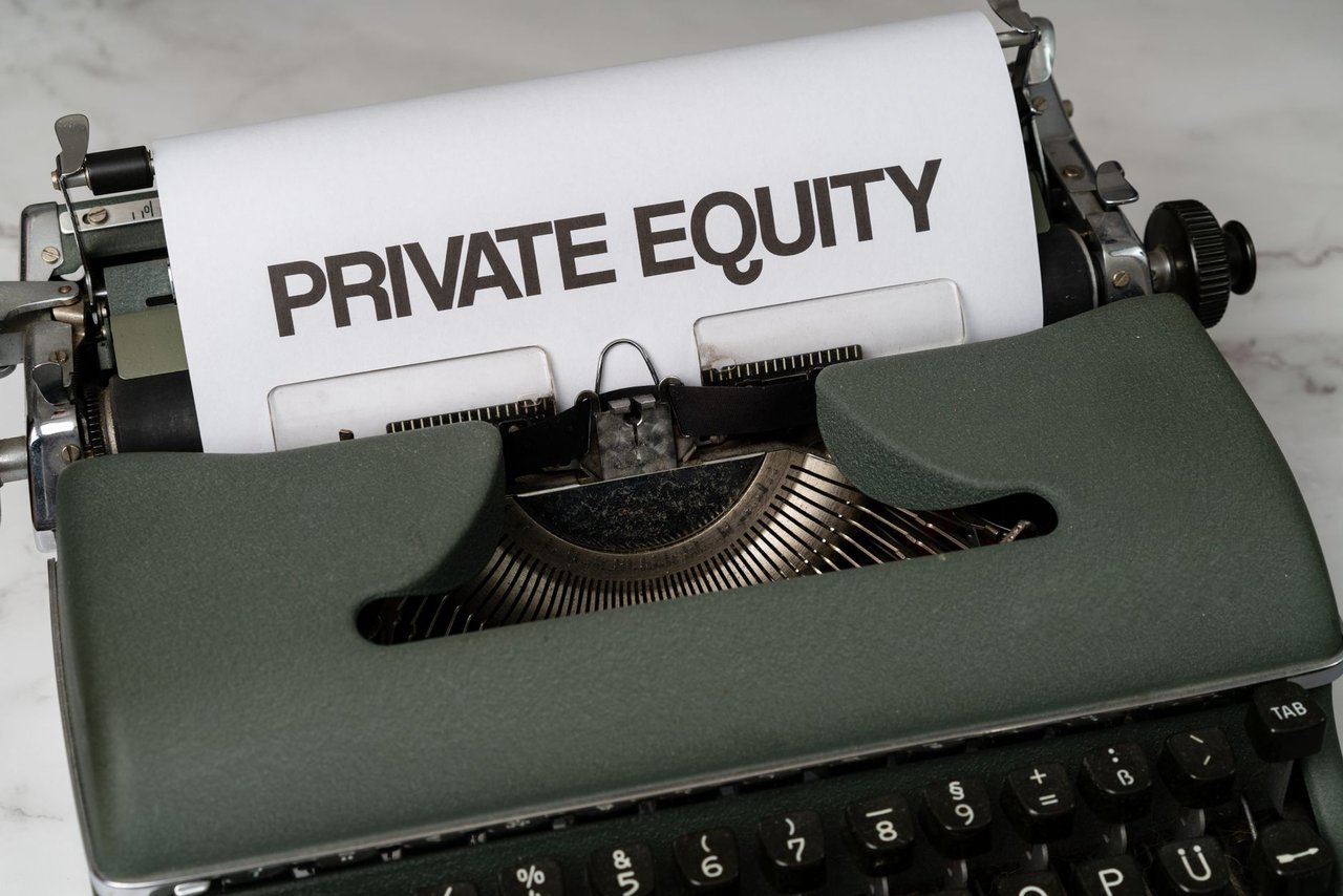 Máquina de escrever vintage com uma folha onde se lê “PRIVATE EQUITY”.