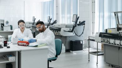 Equipe de pesquisadores analisa dados e equipamentos em um laboratório moderno.