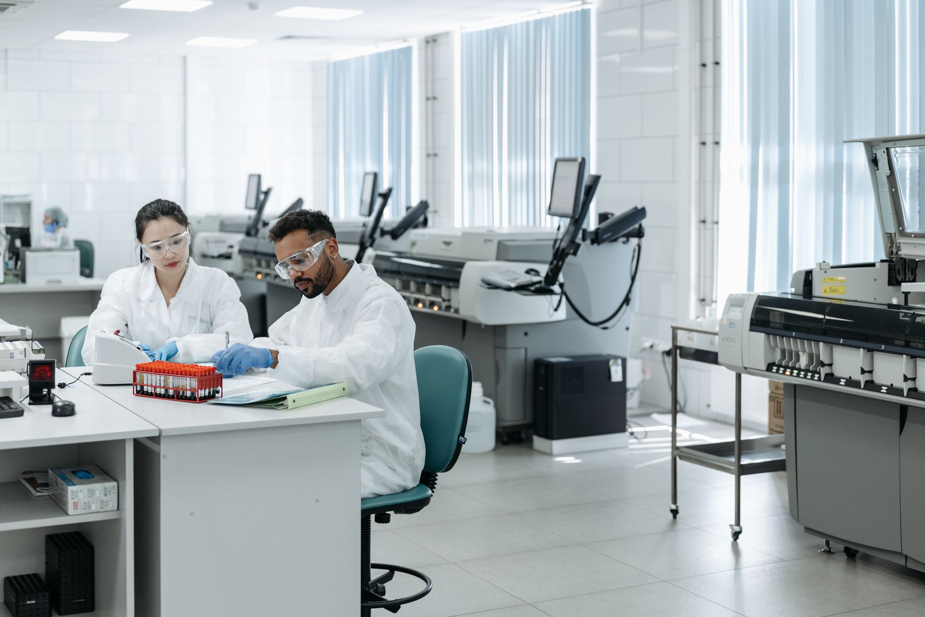 Equipe de pesquisadores analisa dados e equipamentos em um laboratório moderno.